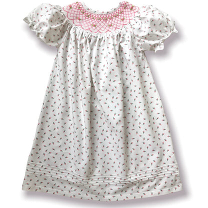 White dress with pink rosebud floral pattern on a white background